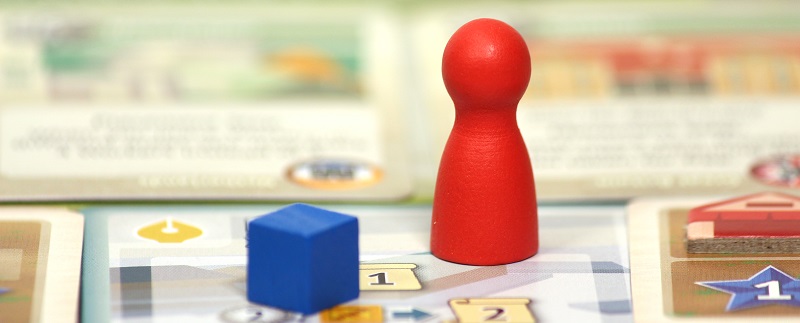 closeup of a red board game miniature placed upon a game board