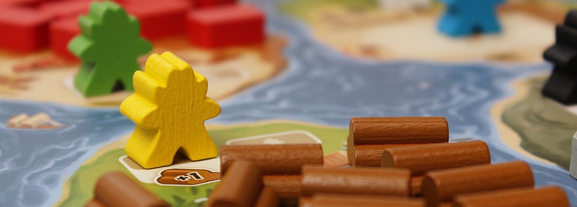 Close-up of multicolored meeples and timber wooden bits on game board